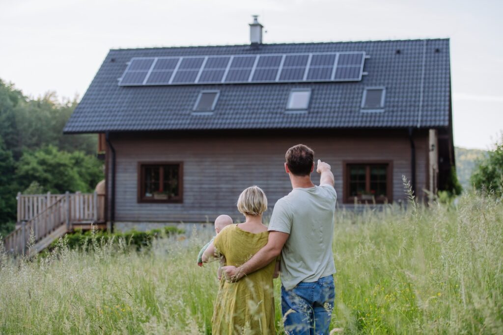 family near their house with a solar panels.